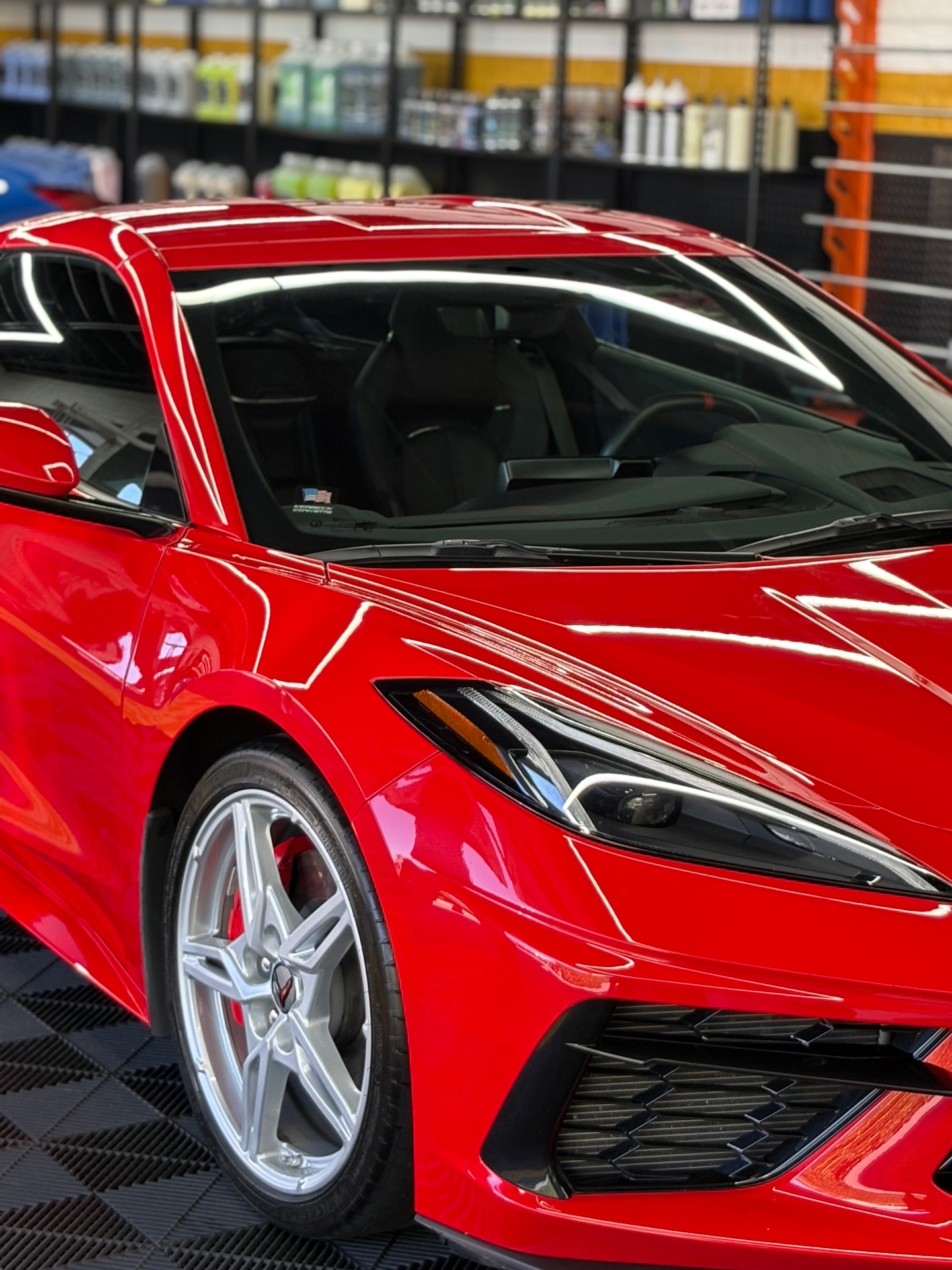 Red Chevrolet Corvette C8 side profile with mirror-gloss reflection after paint correction and ceramic coating